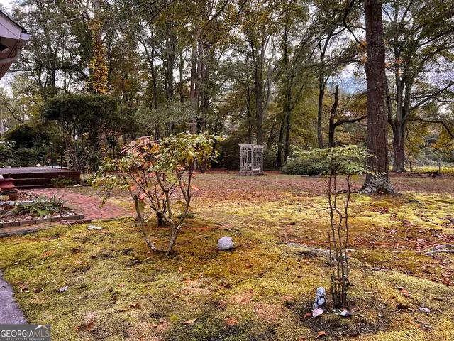 a view of swimming pool with seating area and trees around