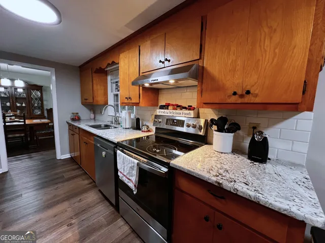 a kitchen with granite countertop stainless steel appliances and wooden cabinets