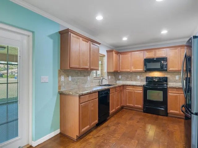 a kitchen with stainless steel appliances granite countertop a refrigerator and a stove top oven