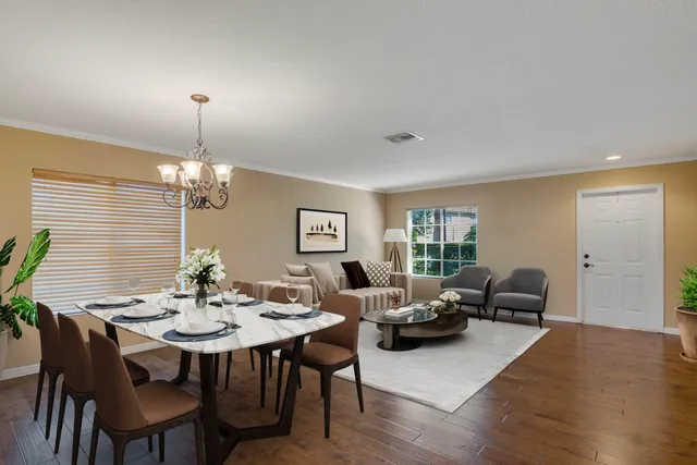 an empty room with wooden floor chandelier and windows