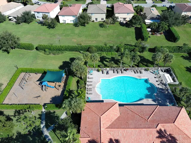 an aerial view of residential houses with outdoor space and trees