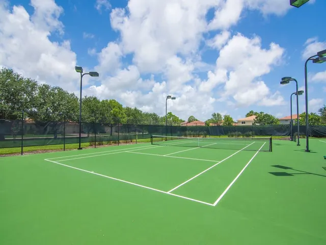 an aerial view of residential houses with outdoor space and trees
