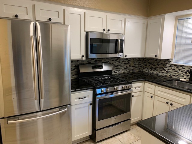 407 West Semands Street Conroe, TX 77301 - Photo 16 of 28 a kitchen with stainless steel appliances a refrigerator stove and microwave