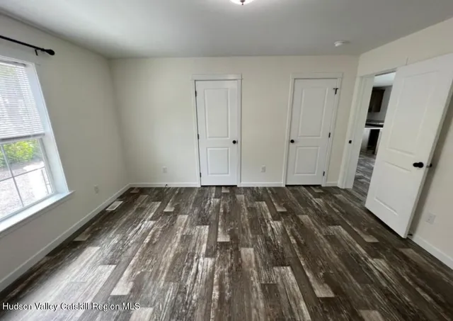 a view of a room with wooden floor and white walls