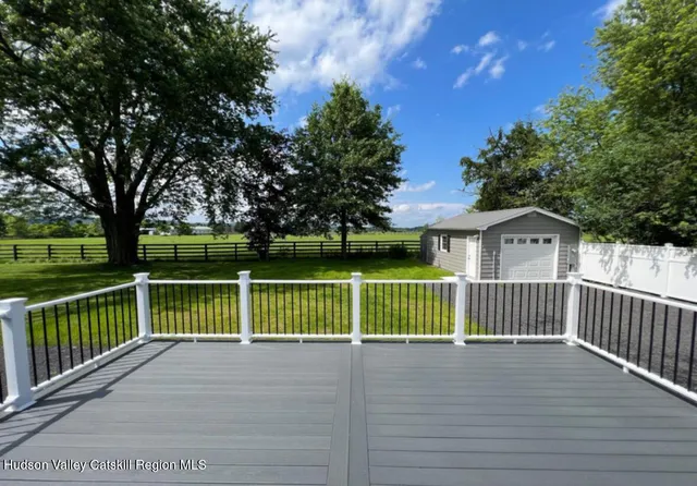 a view of a house with backyard and wooden fence