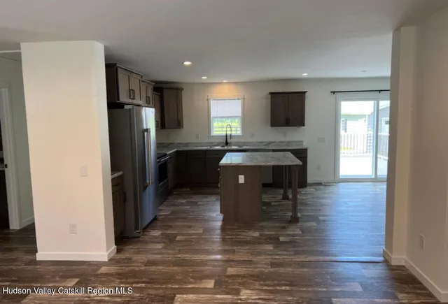 a kitchen with stainless steel appliances granite countertop a refrigerator and a stove top oven