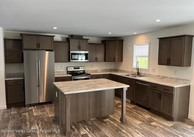 a kitchen with stainless steel appliances granite countertop a sink stove refrigerator and a window