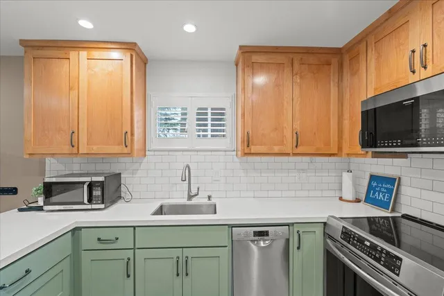 a kitchen with stainless steel appliances a sink stove and cabinets