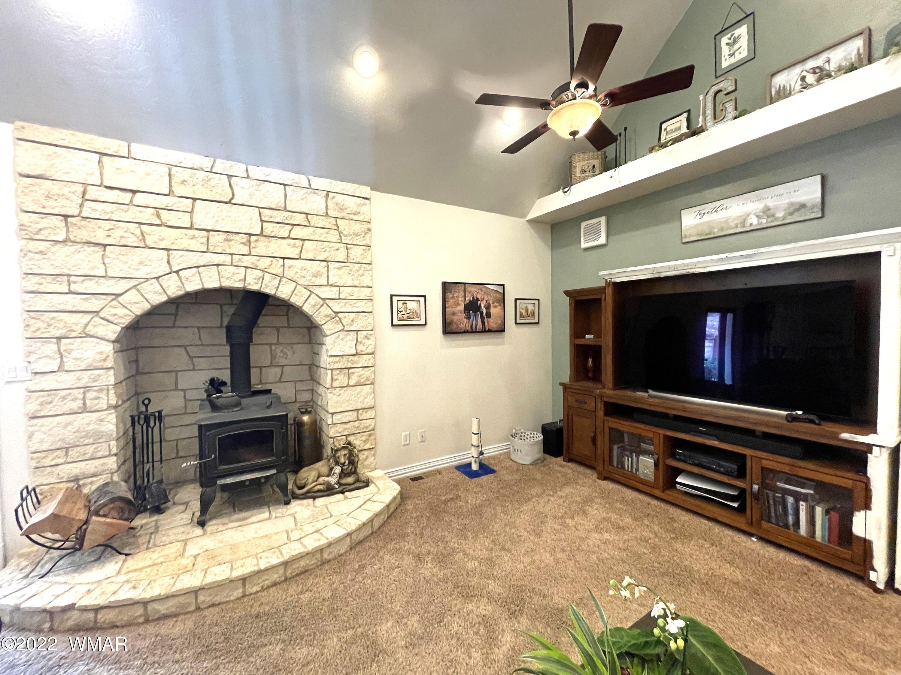 1713 Snowline Road Eagar, AZ 85925 - Photo 13 of 53 a living room with fireplace a flat screen tv and a fireplace
