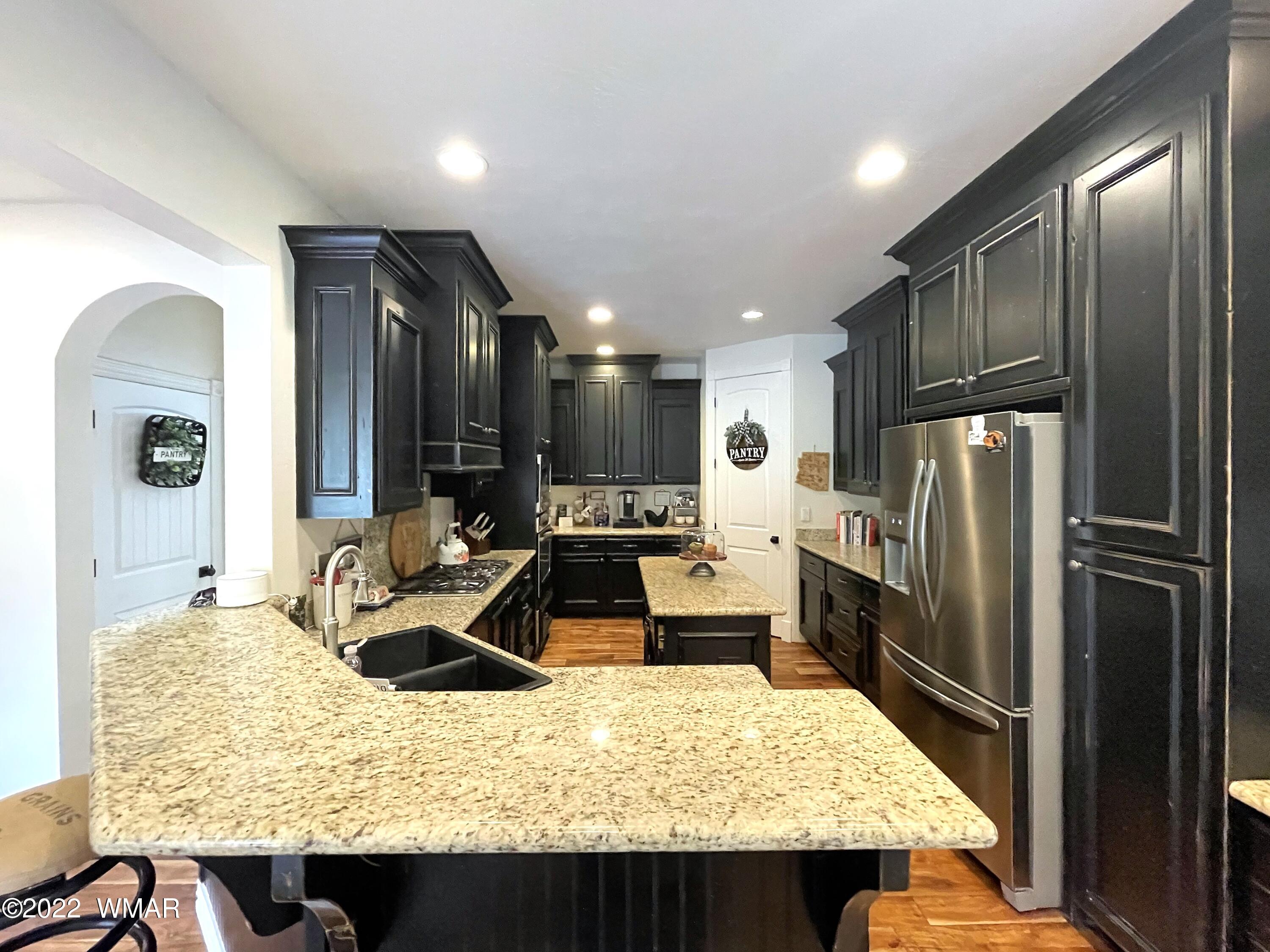1713 Snowline Road Eagar, AZ 85925 - Photo 18 of 53 a kitchen with kitchen island granite countertop a sink refrigerator and cabinets