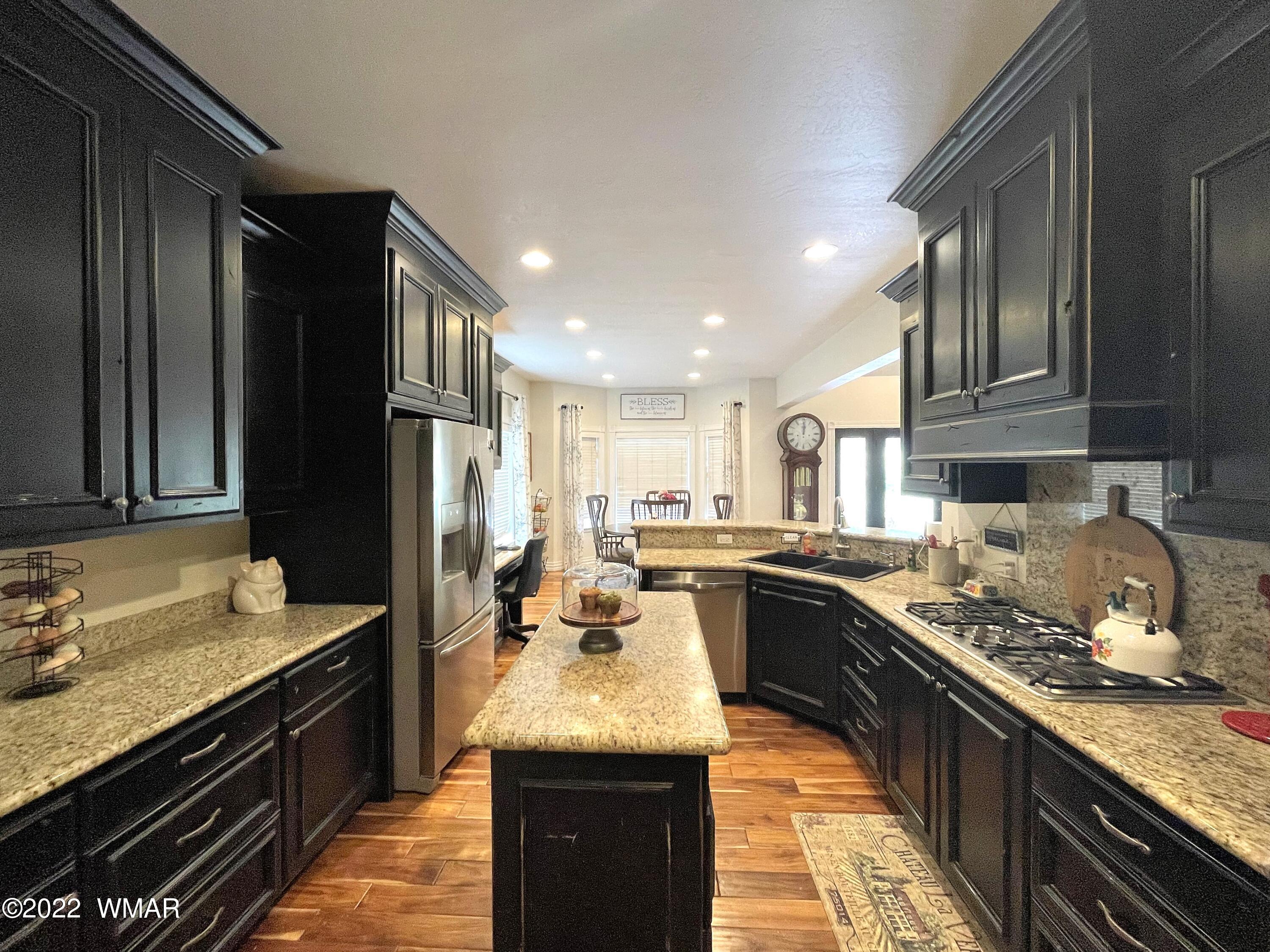 1713 Snowline Road Eagar, AZ 85925 - Photo 19 of 53 a kitchen with granite countertop stainless steel appliances and wooden cabinets