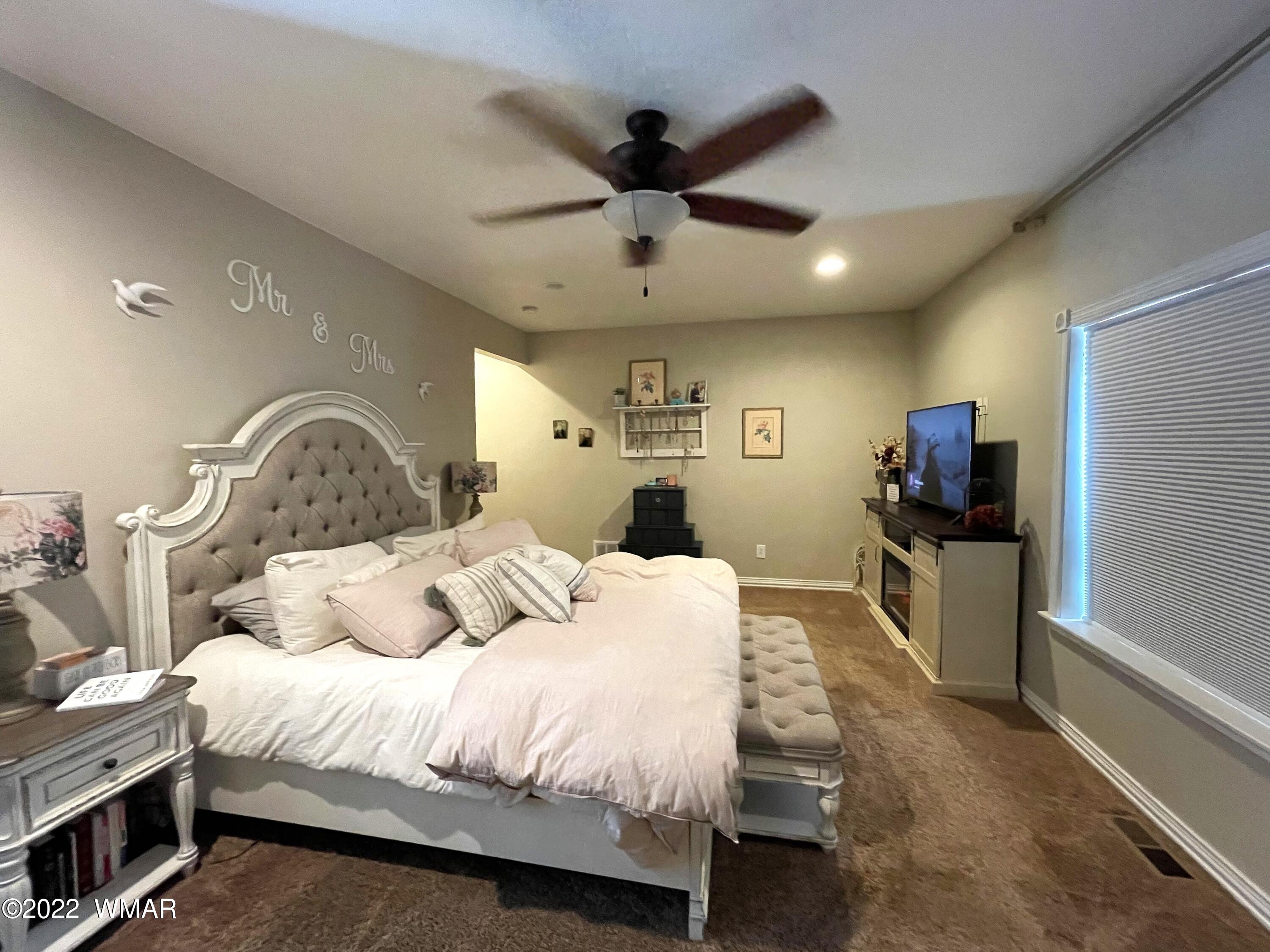1713 Snowline Road Eagar, AZ 85925 - Photo 25 of 53 a bedroom with a bed and a large mirror with a flat screen tv