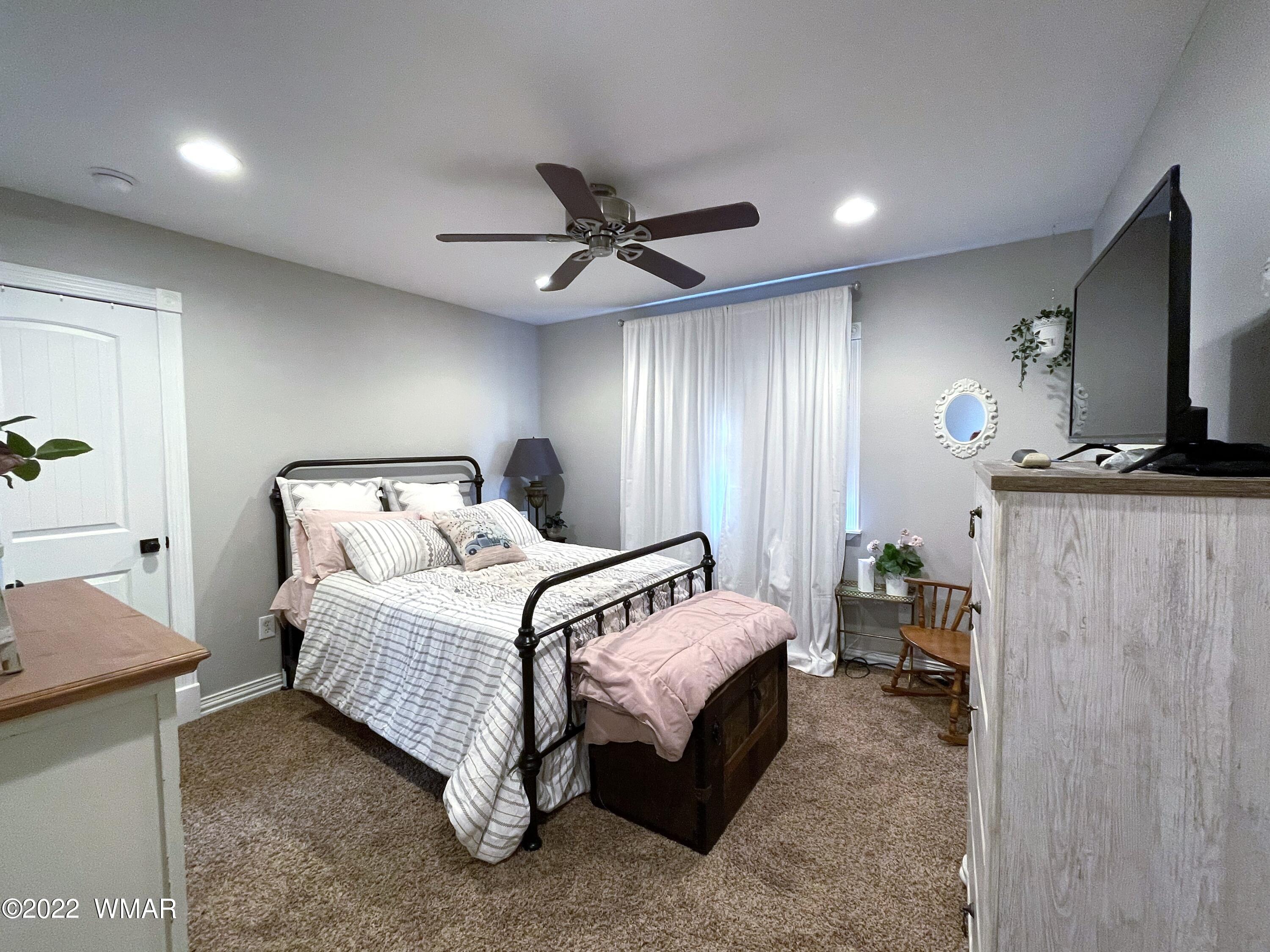 1713 Snowline Road Eagar, AZ 85925 - Photo 38 of 53 a bedroom with bed and a chandelier