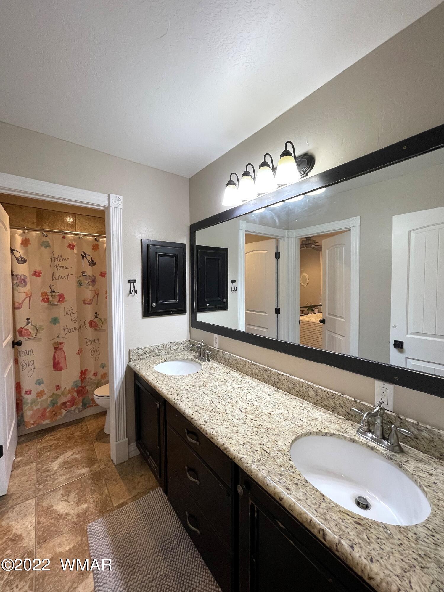 1713 Snowline Road Eagar, AZ 85925 - Photo 45 of 53 a bathroom with a granite countertop sink and a mirror