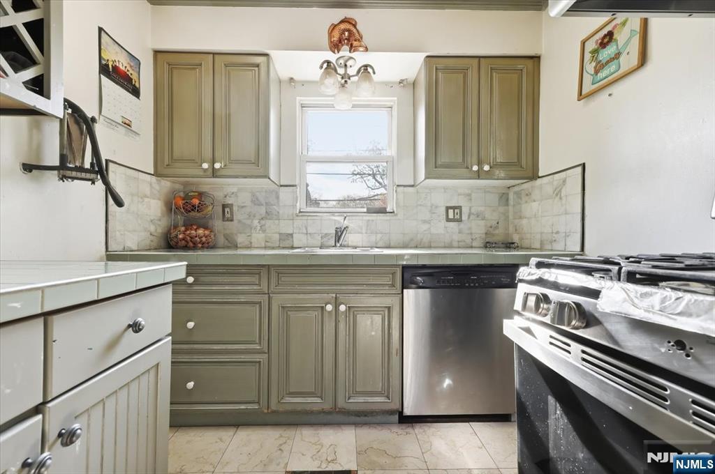 409 Tryon Avenue Englewood, NJ 07631 - Photo 10 of 33 a kitchen with stainless steel appliances granite countertop a sink stove and cabinets