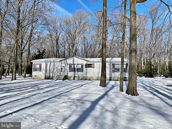a view of a house with a yard covered with snow in the background