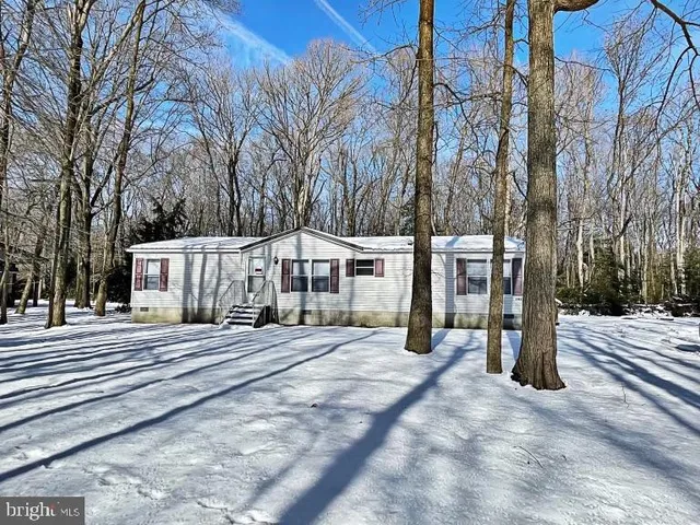 a view of a house with a yard covered with snow in the background