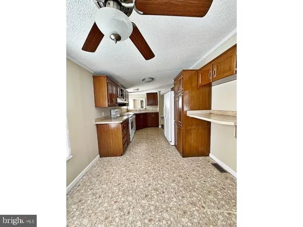 a kitchen with stainless steel appliances kitchen island granite countertop a refrigerator and a sink
