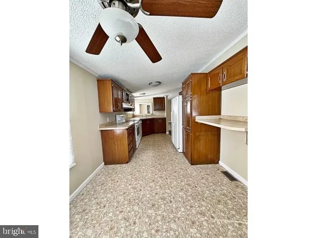 a kitchen with stainless steel appliances kitchen island granite countertop a refrigerator and a sink