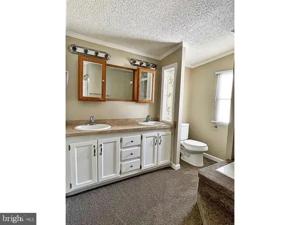 a spacious bathroom with a granite countertop toilet a sink and a mirror