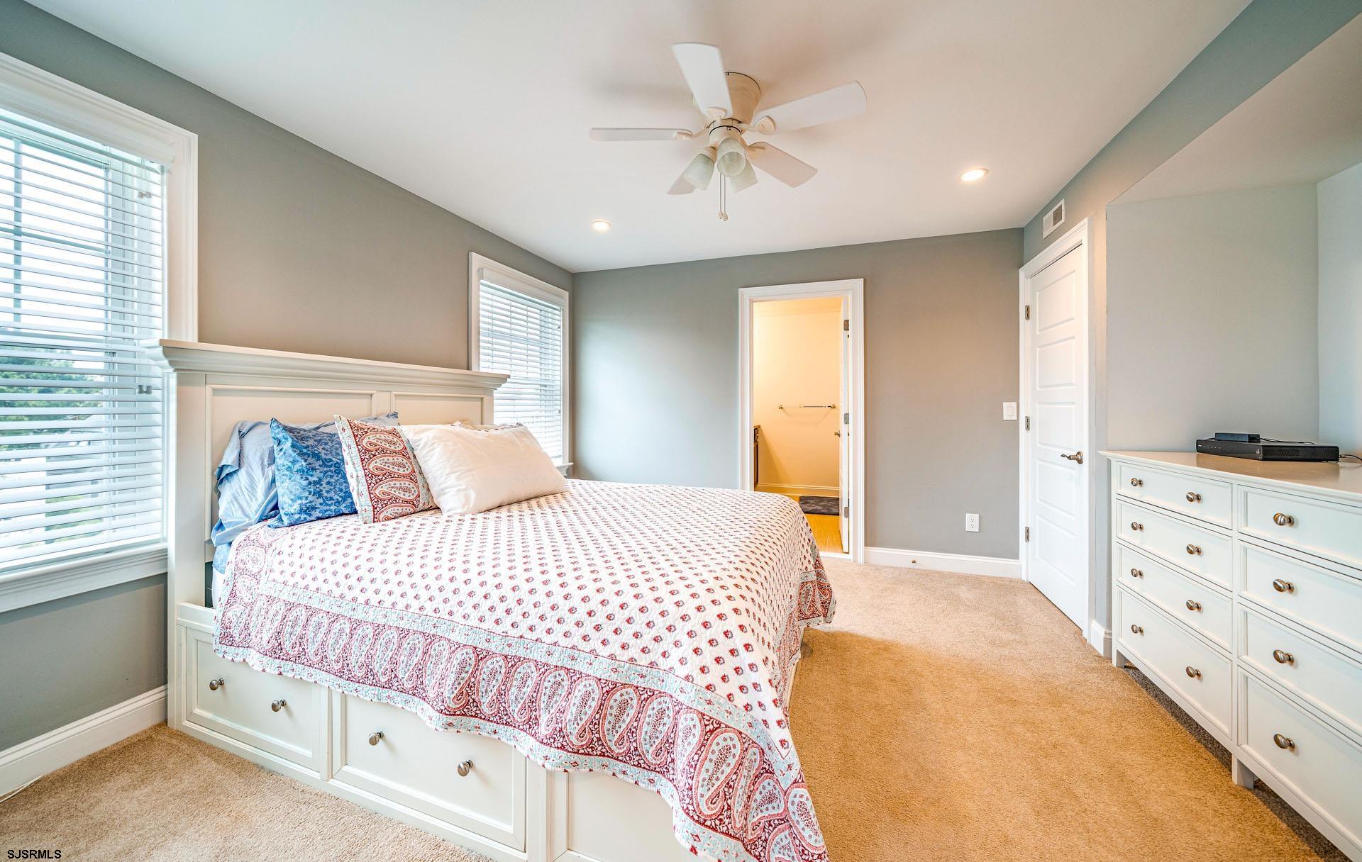 84 East Station Road Ocean City, NJ 08226 - Photo 11 of 30 a bedroom with a bed and a chandelier