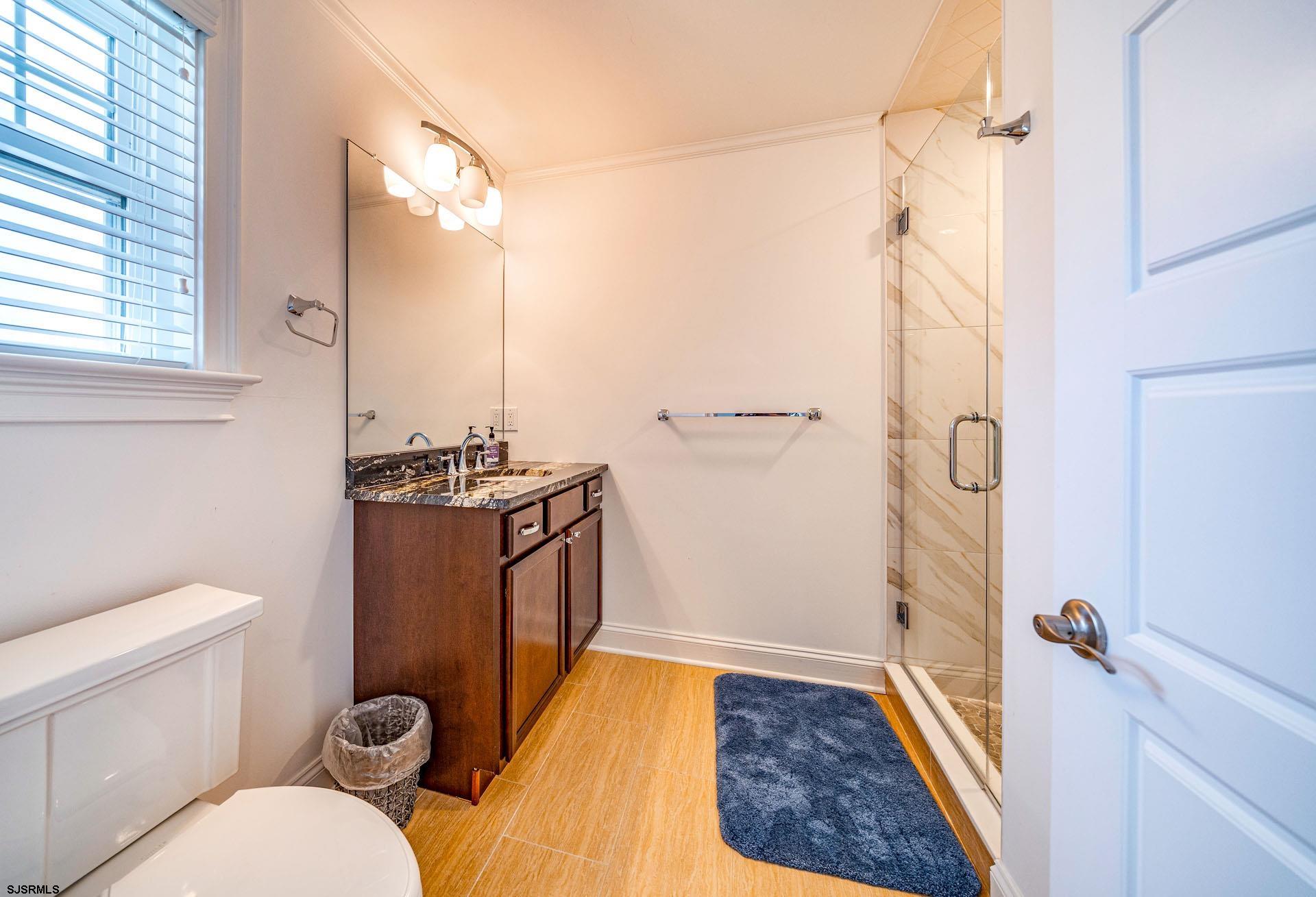 84 East Station Road Ocean City, NJ 08226 - Photo 13 of 30 a bathroom with a sink a toilet a mirror and shower