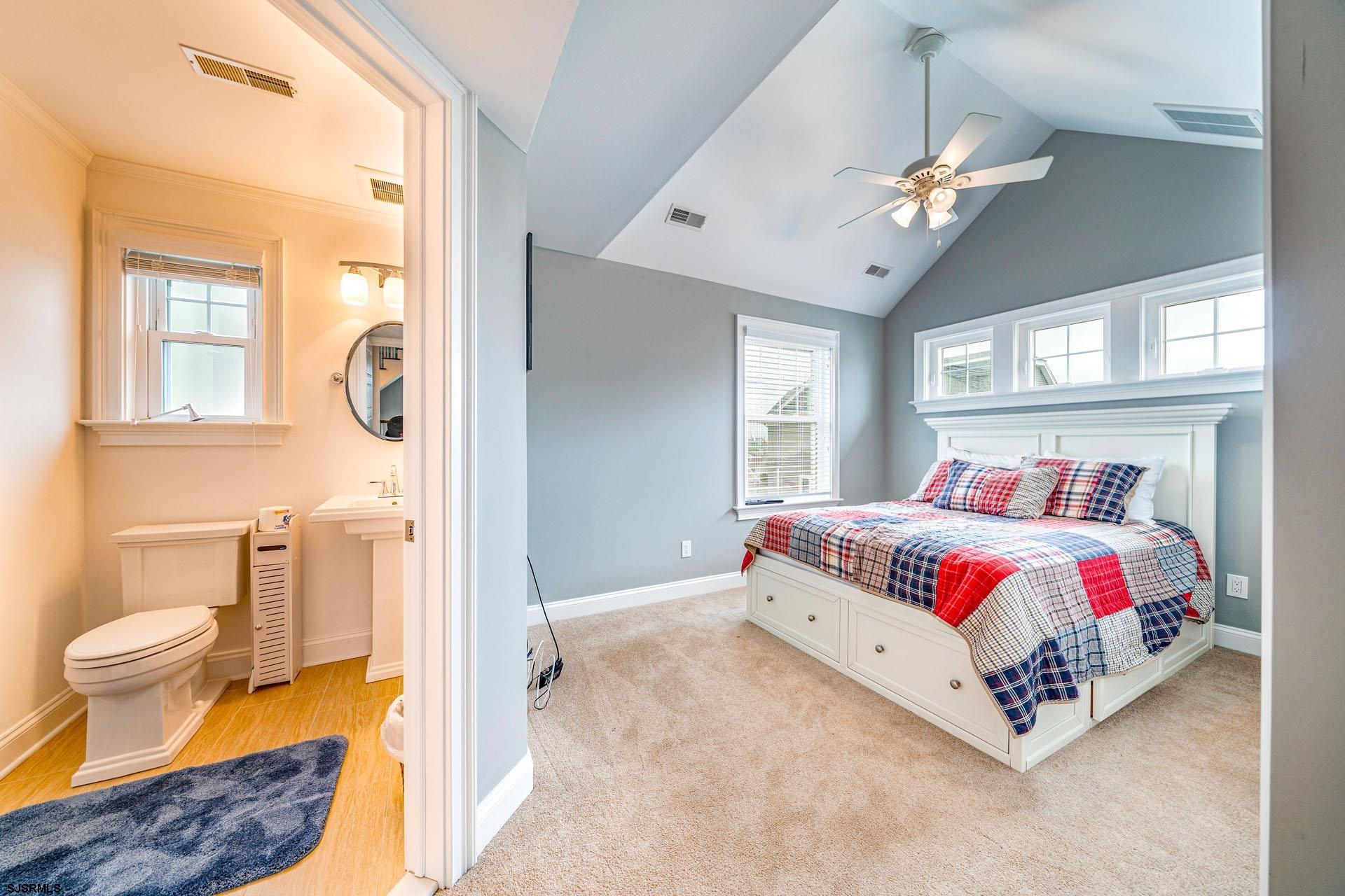 84 East Station Road Ocean City, NJ 08226 - Photo 15 of 30 a bedroom with a bed and a chandelier
