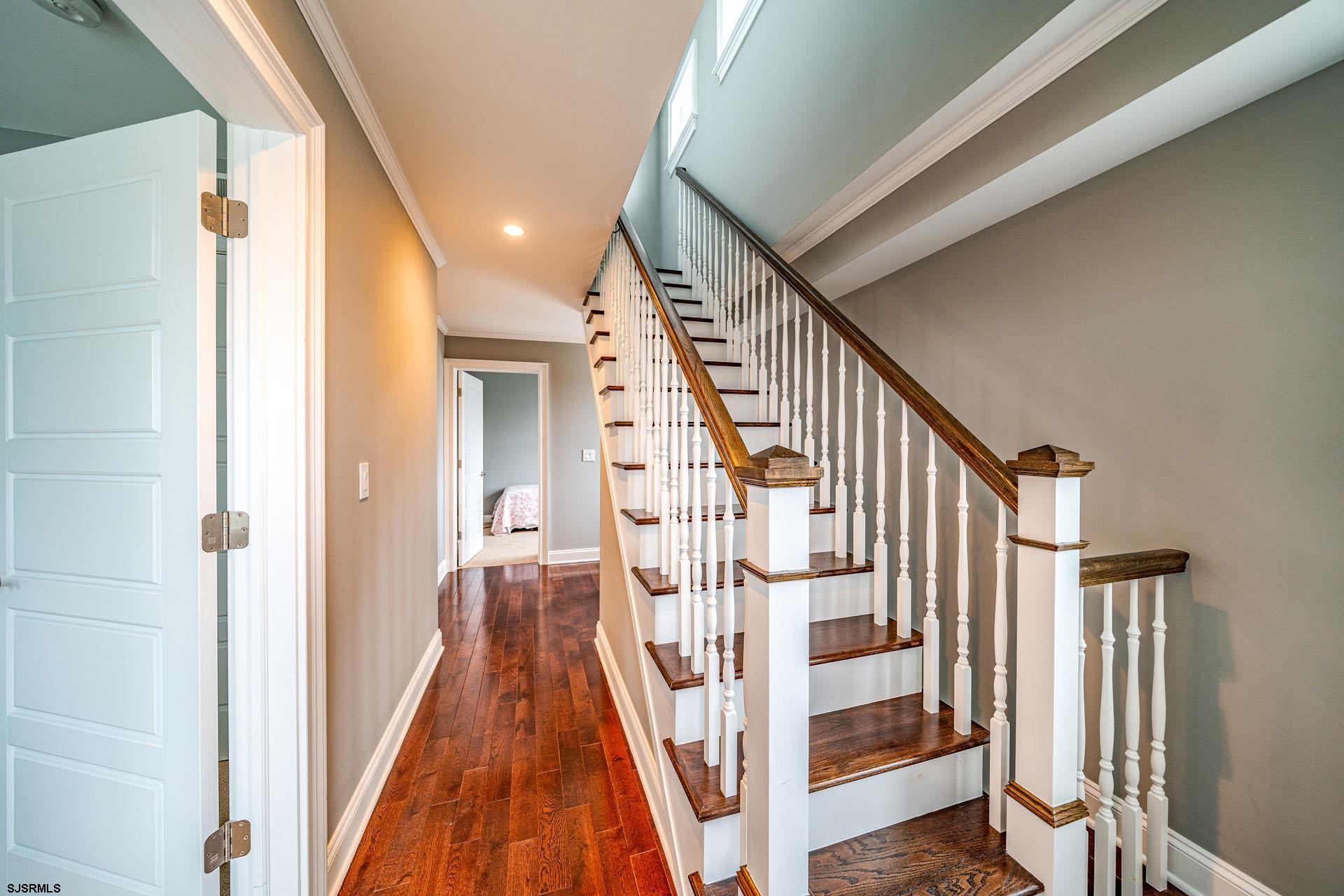 84 East Station Road Ocean City, NJ 08226 - Photo 22 of 30 a view of staircase with lots of frames on wall and wooden floor