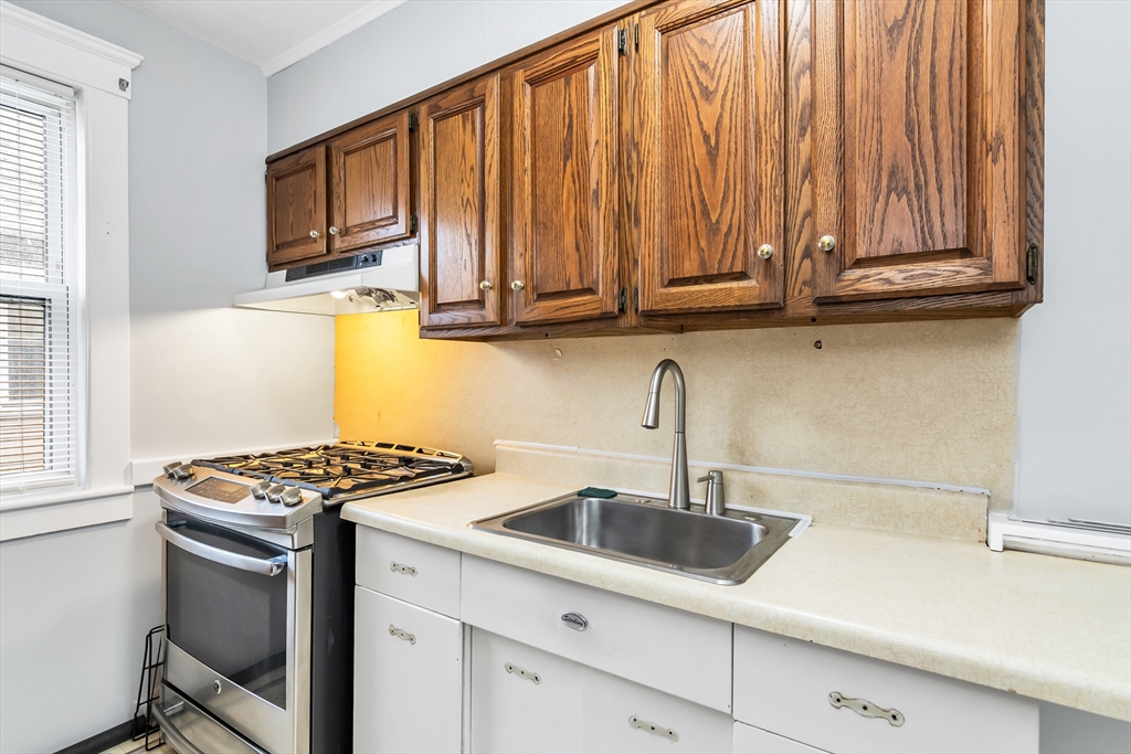 32-34 Magnolia Street, Unit 2 Lawrence, MA 01841 - Photo 10 of 29 a kitchen with stainless steel appliances granite countertop a sink a stove and a microwave
