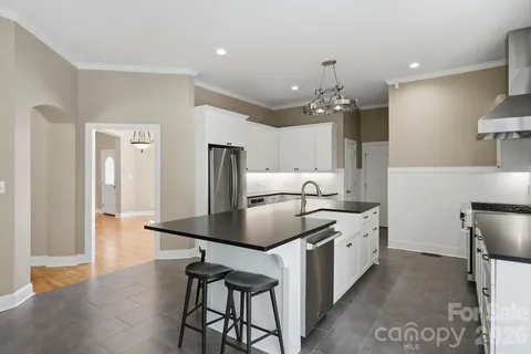 a kitchen with stainless steel appliances granite countertop a sink a stove and a refrigerator