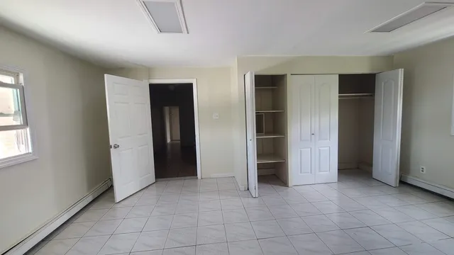 an empty room with closet and windows