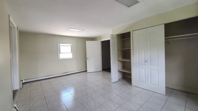 a view of an empty room with window and closet area