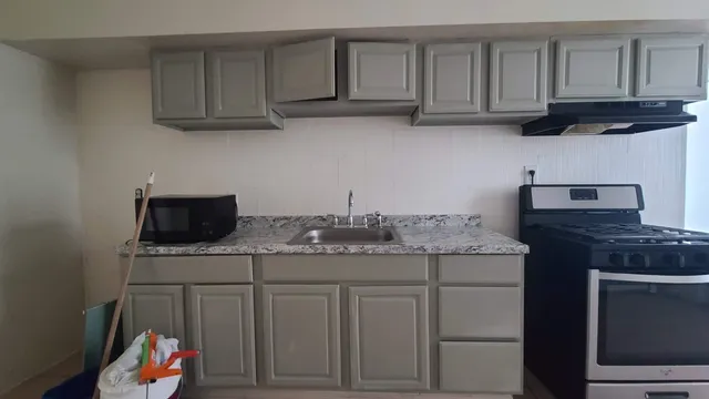 a kitchen with stainless steel appliances granite countertop a sink dishwasher a stove and a microwave oven on granite countertops