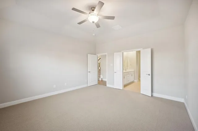 an empty room with a window and a ceiling fan