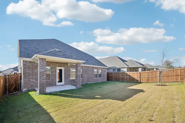 a view of a house with a yard and a large tree