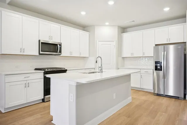 a kitchen with stainless steel appliances granite countertop a refrigerator stove microwave and sink