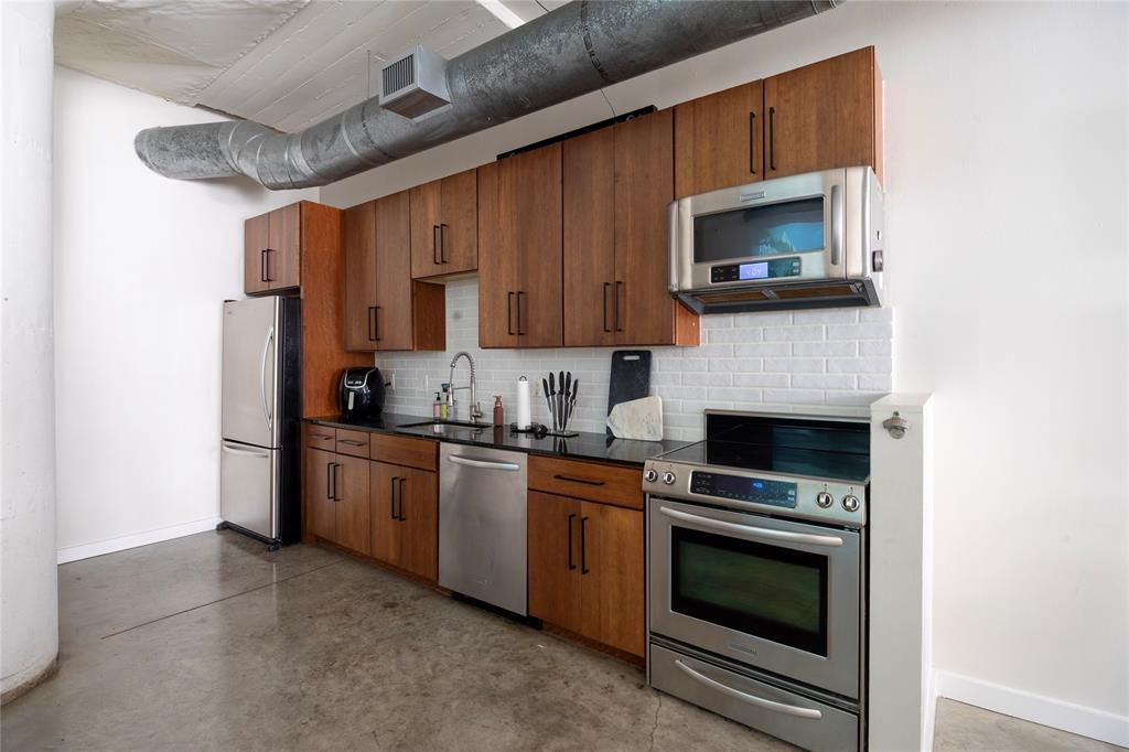 1122 Jackson Street, Unit 618 Dallas, TX 75202 - Photo 11 of 17 a kitchen with stainless steel appliances a stove microwave and sink