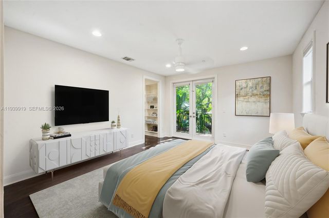 a bedroom with a bed and a flat screen tv