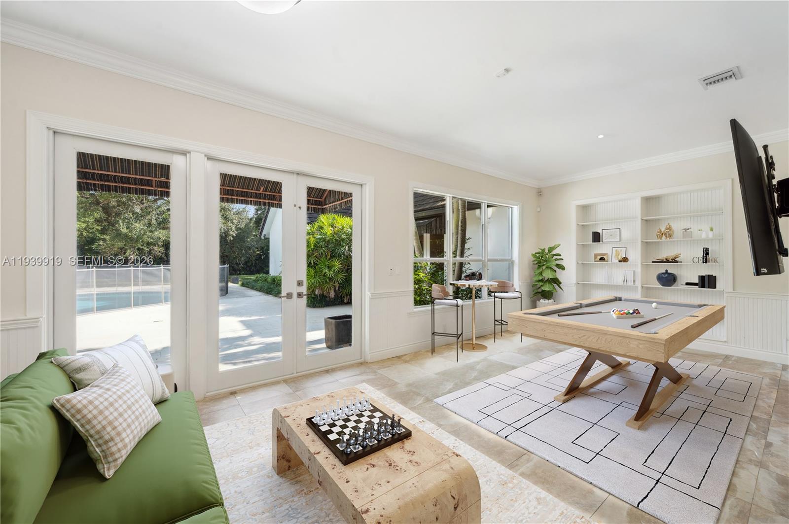 10001 Southwest 60th Court Pinecrest, FL 33156 - Photo 7 of 15 a living room with furniture and a flat screen tv
