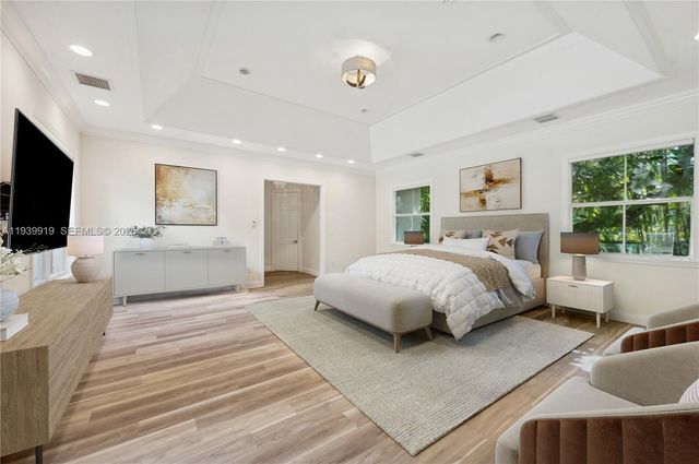 a bedroom with a large bed a flat screen tv and a couch