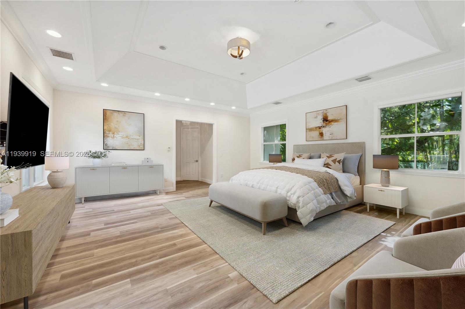 10001 Southwest 60th Court Pinecrest, FL 33156 - Photo 9 of 15 a bedroom with a large bed a flat screen tv and a couch