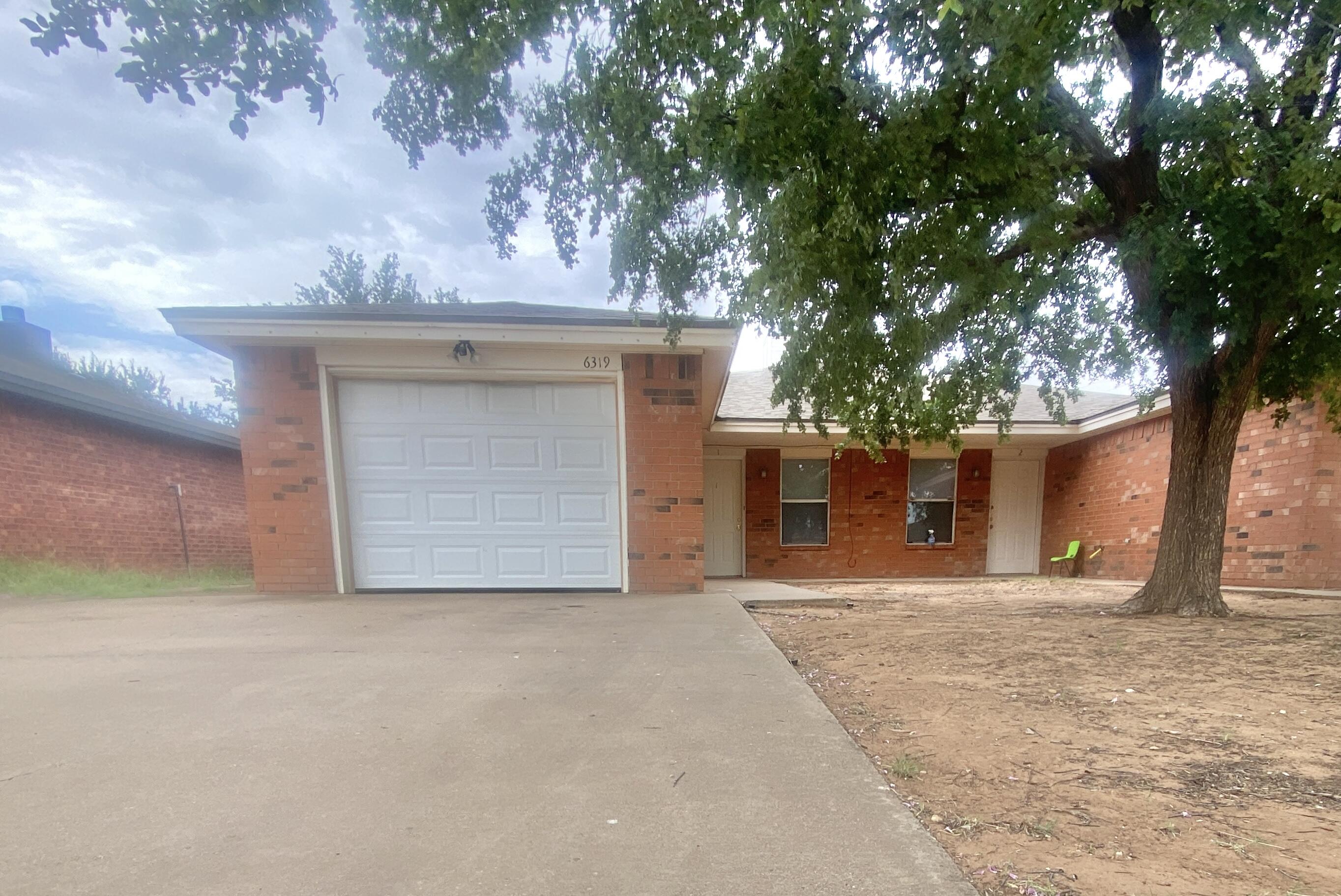 6320 7th Street Lubbock, TX 79416 - Photo 1 of 14 a front view of a house with a yard and garage