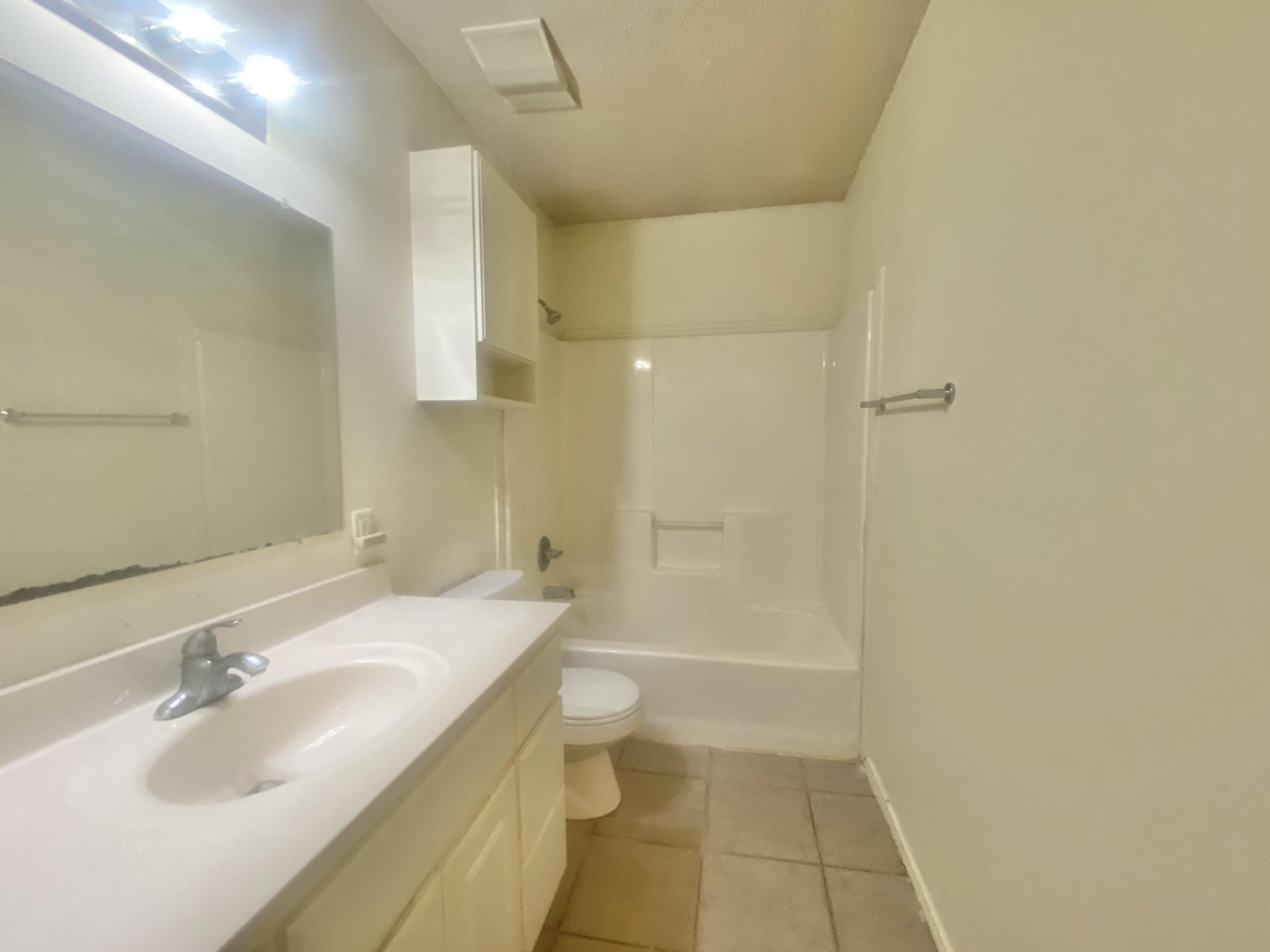 6320 7th Street Lubbock, TX 79416 - Photo 7 of 14 a bathroom with a sink a toilet and shower