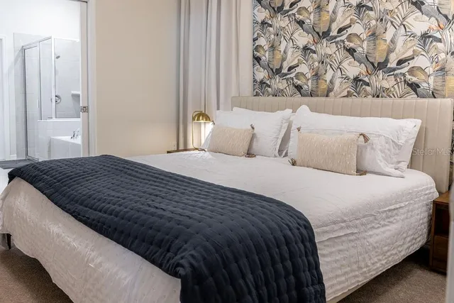 a bed room with a bed a mirror and storage