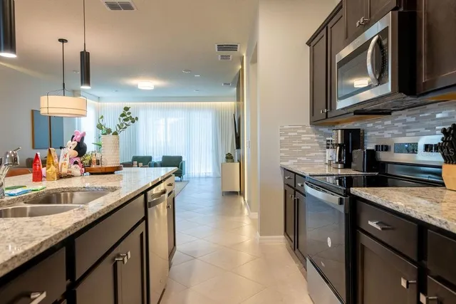 a kitchen with stainless steel appliances granite countertop a refrigerator and a stove top oven