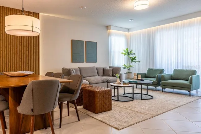 a living room with furniture a dining table and a chandelier