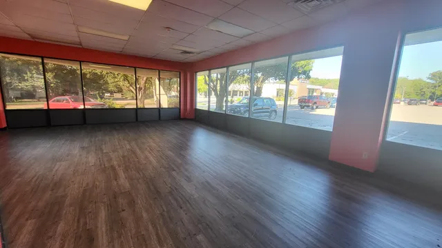 an empty room with wooden floor and balcony