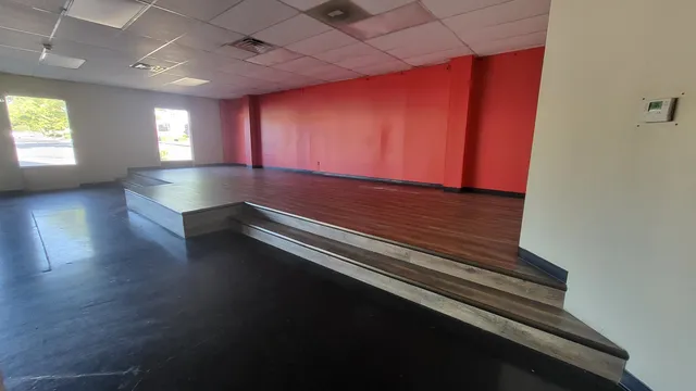 a room with wooden floor and windows