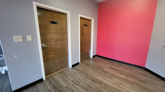 an empty room with wooden floor and a window