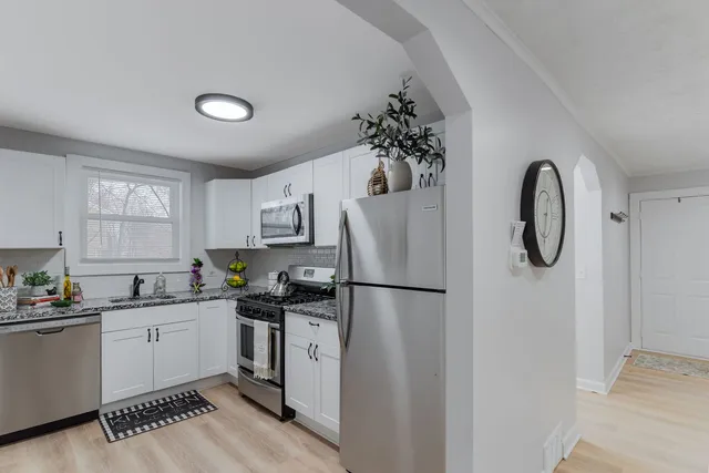 a kitchen with a sink a refrigerator and cabinets